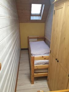 um pequeno quarto com uma cama e uma janela em Erzgebirgshütte em Pobershau