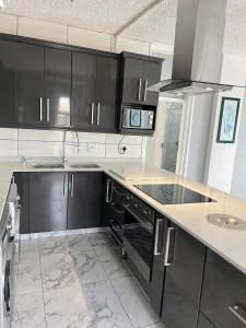 a kitchen with black cabinets and a marble floor at 201 on Seagull in Margate