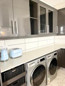 een keuken met 2 wasmachine en drogers op een aanrecht bij 201 on Seagull in Margate