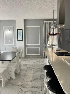 een keuken met witte stoelen en een tafel en een aanrecht bij 201 on Seagull in Margate