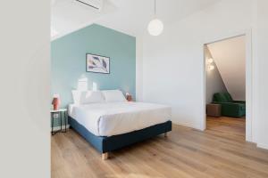 ein Schlafzimmer mit einem weißen Bett und einer blauen Wand in der Unterkunft RELSTAY - Tortona in Mailand