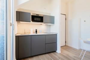 eine Küche mit Spüle und Mikrowelle in der Unterkunft RELSTAY - Tortona in Mailand