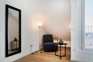 ein Wohnzimmer mit einem Stuhl und einem Spiegel in der Unterkunft RELSTAY - Tortona in Mailand + 48 Fotos