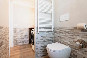 ein Badezimmer mit Toilette sowie Waschmaschine und Trockner in der Unterkunft RELSTAY - Tortona in Mailand