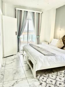 een slaapkamer met een wit bed en een raam bij 201 on Seagull in Margate
