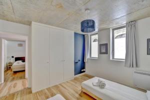 a bathroom with a white sink and a bedroom at Le Faubourg - Charmant duplex pour 4 avec parking in Bordeaux