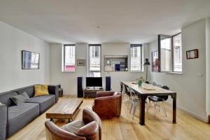 uma sala de estar com um sofá e uma mesa em Le Faubourg - Charmant duplex pour 4 avec parking em Bordéus