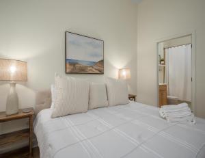 a white bedroom with a white bed with two lamps at 365 Cinnamon Beach in Palm Coast