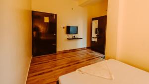 a room with a mirror and a tv in it at Dibrugarh Tea Residency in Dibrugarh +49 photos
