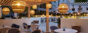un restaurante con mesas, sillas y lámparas de araña en Precioso y tranquilo apartamento zona alta Diagonal Barcelona, en Barcelona