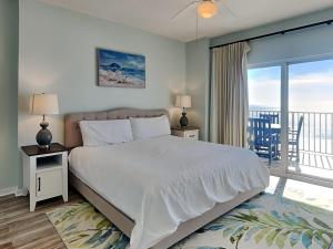 a bedroom with a large bed and a balcony at Tidewater Orange Beach #1003 in Orange Beach +23 photos