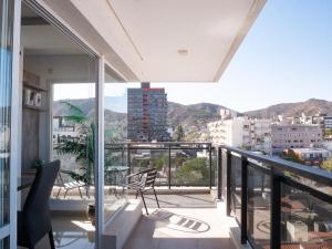 a balcony with chairs and a view of a city at Edificio Leonardo 6to piso in Villa Carlos Paz