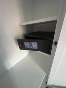 a microwave oven in a white cabinet in a kitchen at Orquídea Real in Villablino