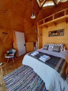 1 dormitorio con 1 cama grande en una cabaña en Zarapito Domo II, domo con tinaja, en Punahuel