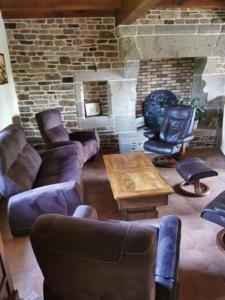 ein Wohnzimmer mit Sofas und einem gemauerten Kamin in der Unterkunft Un havre de paix in La Méaugon