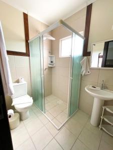 a bathroom with a shower and a toilet and a sink at Morada Baden Baden in Bombinhas