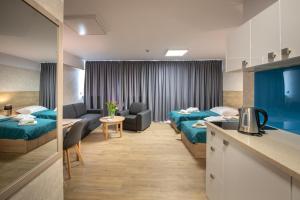 a hotel room with two beds and a kitchen at Jubilat in Lądek-Zdrój