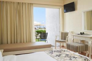 a hotel room with a bed and a balcony at Civitel Creta Beach in Amoudara Herakliou