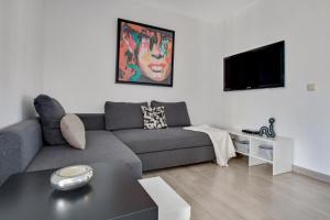 a living room with a couch and a tv at Imperial Puerto 2 4B By IVI Real Estate in Torremolinos