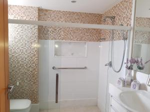 a bathroom with a shower and a toilet and a sink at RICARDO Pousada Q1 Suíte in Vila Velha