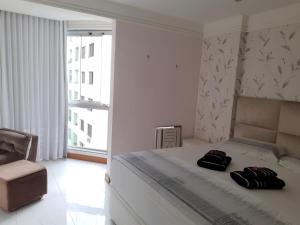 - une chambre avec un lit et 2 serviettes dans l'établissement RICARDO Pousada Q1 Suíte, à Vila Velha