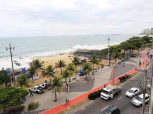a city street with cars parked on a beach at RICARDO Pousada Q1 Suíte in Vila Velha