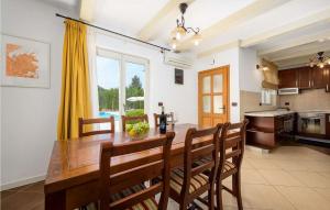 Il comprend une cuisine et une salle à manger avec une table et des chaises en bois. dans l'établissement Casa Rita Porec, à Poreč