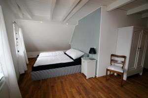 ein kleines Schlafzimmer mit einem Bett und einem Stuhl in der Unterkunft Dorphus in Neuenkirchen auf Rügen