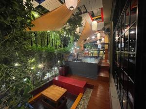 a restaurant with a bench and a bar with plants at อีโฮสเทลบ้านช่น in Ban Chak Khamin