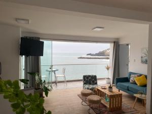 Sala de estar con sofá azul y vistas al océano en FRENTE AL MAR, en San Bartolo