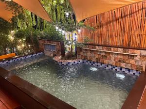 an indoor koi pond in a backyard with a stone wall at อีโฮสเทลบ้านช่น in Ban Chak Khamin