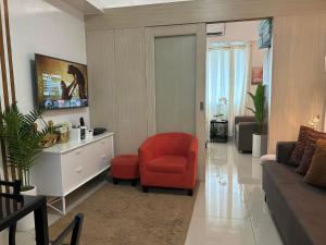 a living room with a red chair and a couch at Rich Staycation Makati in Manila