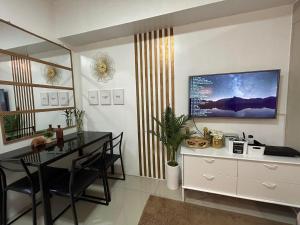 a dining room with a table and a television on the wall at Rich Staycation Makati in Manila