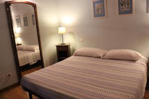 イゼーオにあるCascina Clarabellaのベッドルーム(ベッド1台、大きな鏡付)