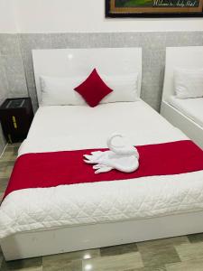 a bed with two white towels on a red blanket at Phú Gia 464 NVL in Ho Chi Minh City
