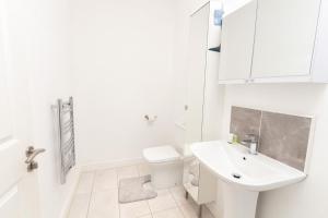 Modern Stylish 1Bed Apartment in Birkenhead في بيركينهيد: حمام أبيض مع حوض ومرحاض