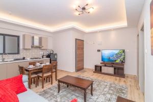 a living room with a table and a kitchen at Spacious 1-Bed Apt at Elite (7D) in Nairobi