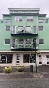 阿克雷里的住宿－Akureyri Backpackers, Hafnarstraeti 100 - Apartment for 4，一座大型绿色建筑,设有两个阳台