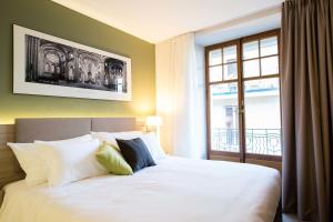 En eller flere senger på et rom på Hôtel des Voyageurs Boutique
