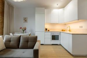 a living room with a couch and a kitchen at Fabryczna 19 by Farkas Apartments in Poznań