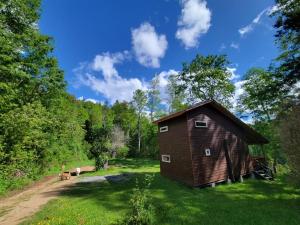 a barn in the middle of a field with two cows at Entre Pampa y Bosque in Villarrica