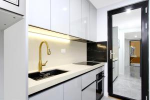 a kitchen with white cabinets and a sink at Executive Suite in Strathnairn