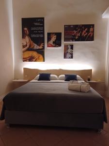 una camera da letto con un letto con poster appesi al muro di Domus Duomo B&B Napoli a Napoli