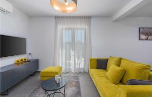 ein Wohnzimmer mit einem gelben Sofa und einem TV in der Unterkunft Villa Hizina Veleniki in Poreč