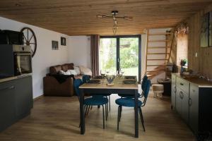cocina y comedor con mesa y sillas en Gite de la Ravanne/Le petit nid en Ramonchamp