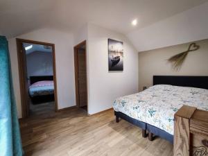 1 dormitorio con cama y espejo en Gite de la Ravanne/Le petit nid en Ramonchamp
