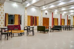 Großes Zimmer mit Stühlen, Tischen und Stühlen in der Unterkunft Hotel Welcome Sri Vip Road Raipur in Phundardih