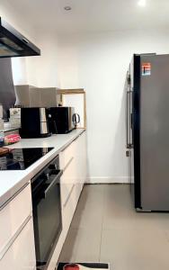 eine Küche mit einem Kühlschrank aus Edelstahl und weißen Arbeitsflächen in der Unterkunft Stylish and Unique Bedroom In Gateshead - Close To Newcastle in Sheriff Hill