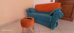 a blue couch with a remote control on a stool at *Piazza Italia* Vicino Autostrada*Roma 40 min.* in Orte