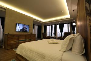 a hotel room with a bed and a television at Hotel 1 Maji in Pogradec